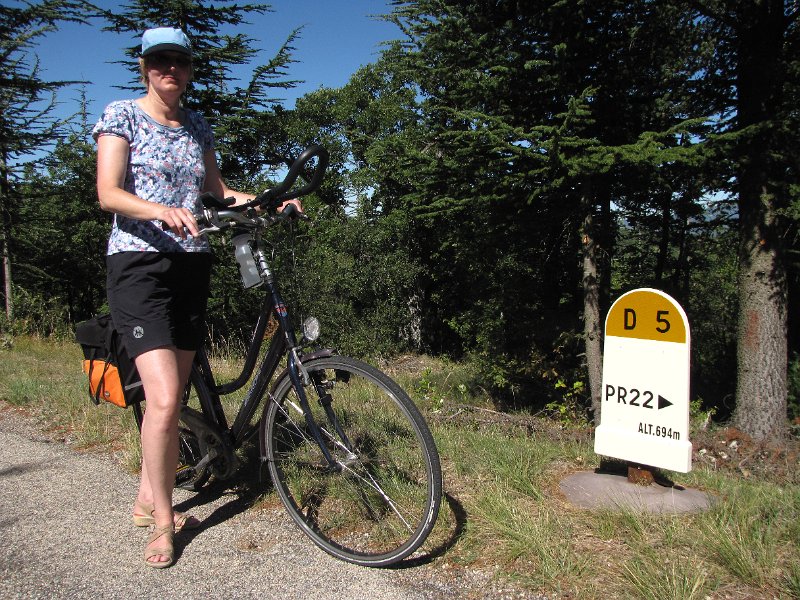 frouwkje met hoogtebord.jpg - We gaan weer een dagje fietsen. Dit keer een route "sportif" waarbij we stevig moeten klimmen. Af en toe komen we dan zo'n bord tegen waardoor we een idee hebben hoeveel we omhoog gaan.